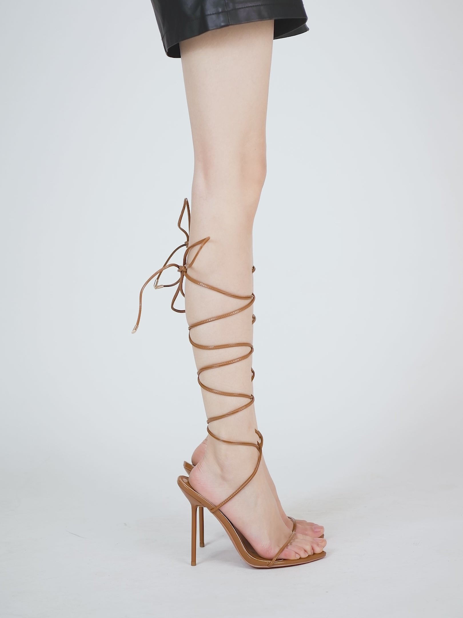 High-shine tan patent sandals in vegan leather with modern design