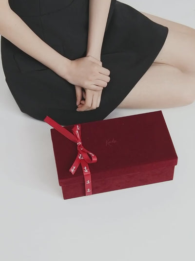 Top view of burgundy patent lace mules with rich colour and intricate texture
